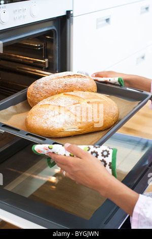 Frau backen Brot im Backofen Küche Stockfoto