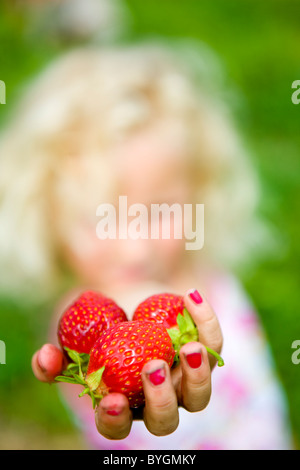 Mädchen halten Erdbeeren Stockfoto