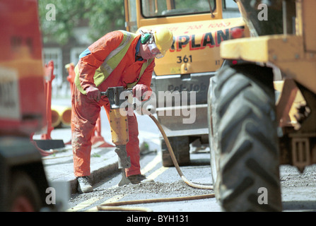 Stadtwerke. Mann auf einer Straße mit einem Presslufthammer arbeiten Stockfoto