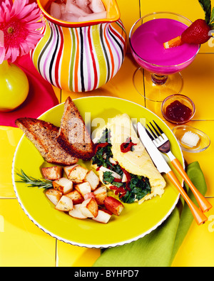 Essen - Broccoli Rabe und Fontina-Käse-Omelette mit Sonne getrockneten Tomaten, serviert mit Toast und Kartoffeln. Stockfoto