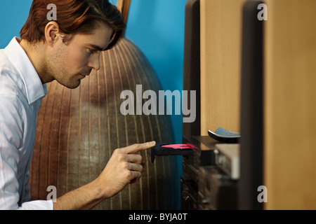 kaukasischen erwachsenen Mann spielt CD in Stereo. Horizontale Form, Seitenansicht, Kopf und Schultern Stockfoto