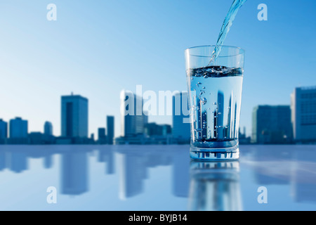 Glas Wasser gießen Trinken Skyline städtische Szene Stockfoto