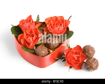 Rote Rosen und Trüffel in einer herzförmigen Schachtel Stockfoto