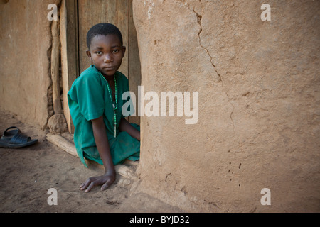 Ein Kind sitzt in der Tür ihres Hauses in Masaka, Uganda Stockfoto