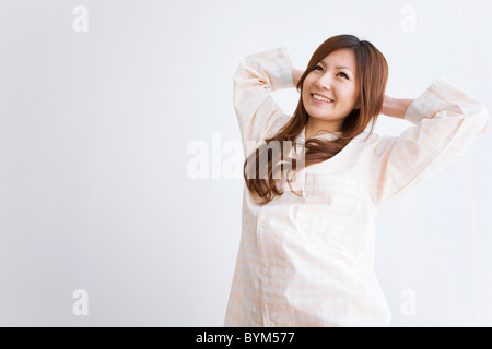 Junge Frau im Schlafanzug Stretching Stockfoto