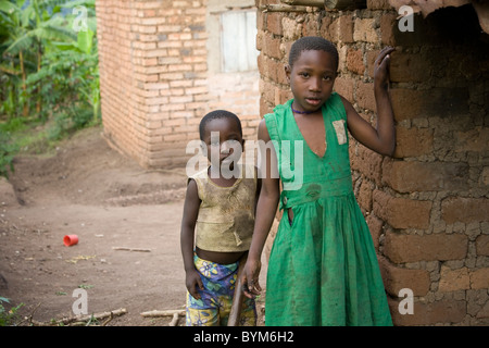 Zwei Kinder stehen vor ihrem Haus in ländlichen Masaka, Uganda, Ostafrika. Stockfoto