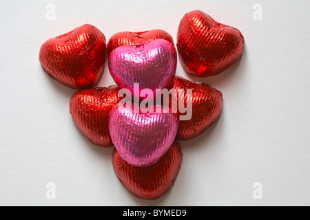 Rosa und rote Folie eingewickelt herzförmige Pralinen in Form von Herzen zum Valentinstag angeordnet, Valentines Tag Stockfoto