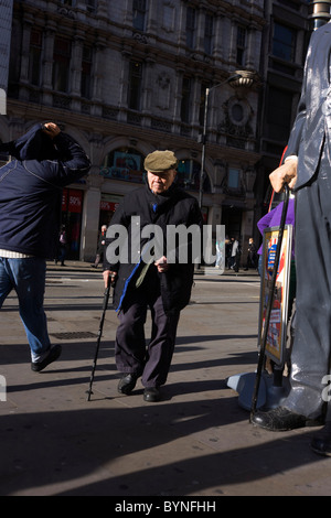 Scale Modell der weltweit größte Mann Robert Pershing Wadlow in London Straße mit älterer Herr mit Stick. Stockfoto