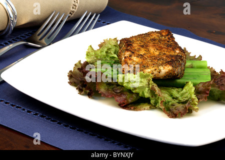 köstlichen gegrillten Wolfsbarsch, gewürzt mit feinen Gewürzen mit Spargel und Salat-Bett Stockfoto