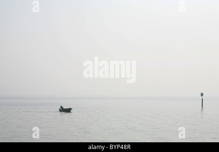 Einsamer Fischer in einem Boot Stockfoto