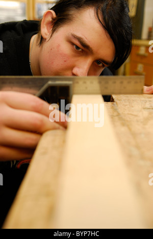 Junger Mann gewinnt Holzarbeiten Fähigkeiten als Teil einer Initiative, junge Menschen in Arbeit, Bristol, UK erhalten. Stockfoto