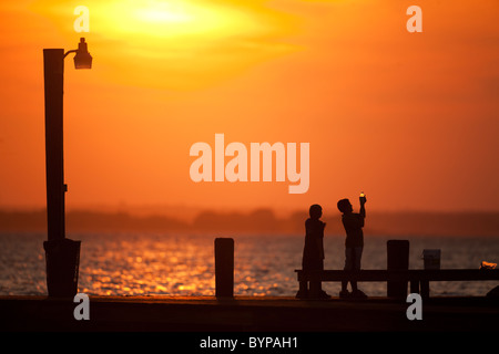 USA, New Jersey, Lavallette, Silhouette von jungen spielen am Boardwalk bei Sonnenuntergang am Sommerabend Stockfoto