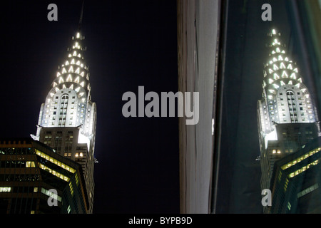 USA, New York, New York City, Chrysler Building spiegelt sich in der Glasfassade des nahe gelegenen Bürogebäudes in der Nacht Stockfoto