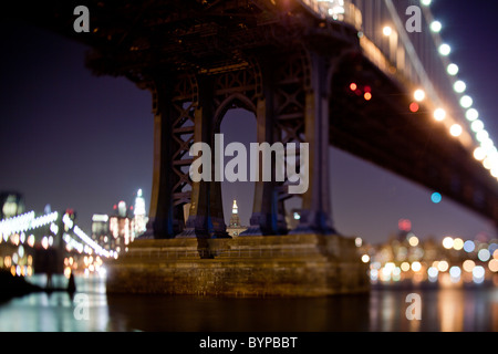 USA, New York, Brooklyn, verschwommene Bild der Brooklyn Bridge und die Skyline von Lower Manhattan bei Nacht entlang East River Stockfoto