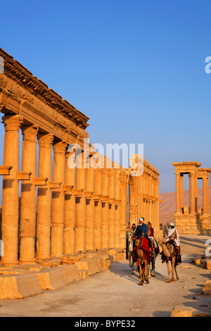 Touristen, Kamelreiten entlang der Colonnaded Straße, Palmyra, Syrien Stockfoto