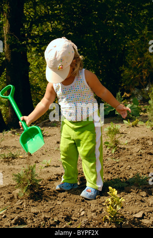 die kleine Gärtnerin mit Kinder-Schaufel. Natur Stockfoto