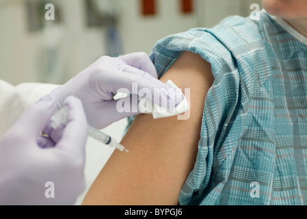 Herr Doktor Platzierung Gaze am Arm des Patienten nach der Verabreichung ein Schuss Stockfoto