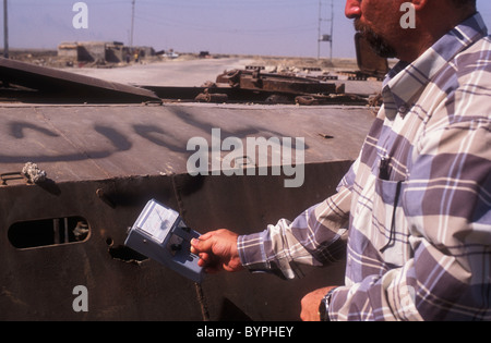 Basra Irak 2004. Ein Wissenschaftler messen die Anwesenheit von Uran auf ein Geigerzähler neben den Überresten einer irakischen Truppentransporter Stockfoto