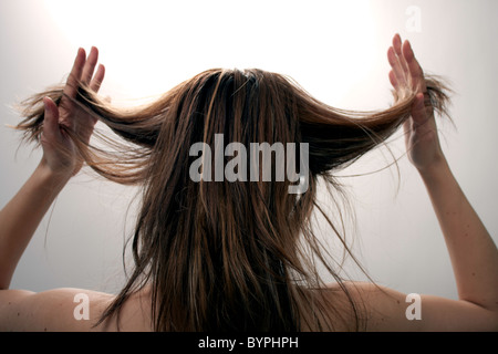 Der Rückseite des einen jungen weiblichen kaukasischen Frau, die ein bad Hair Day ziehen ihr Haar Stockfoto