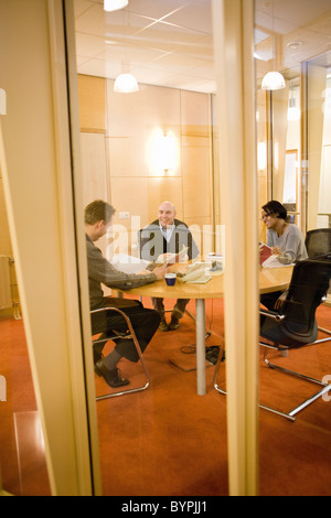 Kolleginnen und Kollegen diskutieren Teppich Proben im Tagungsraum Stockfoto