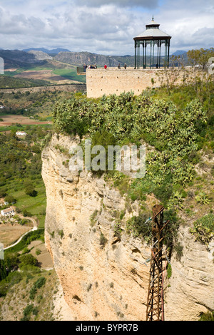 Aussichtsplattform – ganz links – für Menschen, die berühmte steinerne Brücke und die tiefe Schlucht in der spanischen Stadt Ronda, Spanien zu sehen. Stockfoto