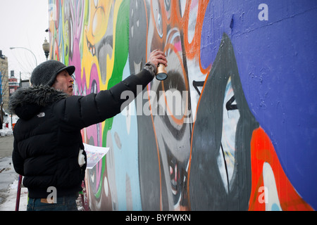 Der Künstler Kenny Scharf repariert sein Wandbild an der Ecke Bowery und Houston Street in New York Stockfoto