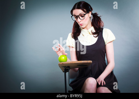 geeky Schulmädchen geht zu Apple auf ihrem Schreibtisch holen Stockfoto