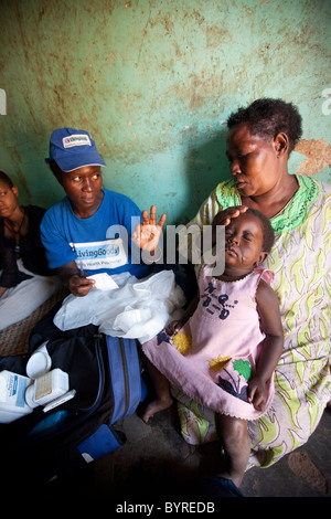 Gesundheitswesen Heimarbeiter mit der NGO Leben Ware macht einen Besuch in eine Frau und ihre Kinder an Malaria in Kampala. Stockfoto