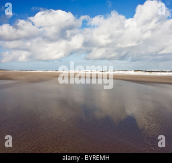 Wolken spiegeln sich in den nassen Sand der Druridge Bucht auf der Northumbrian Küste, Northumberland, England Stockfoto