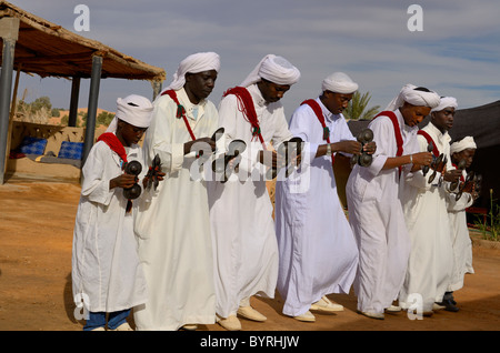 Gruppe von gnawa Musiker in weissen Turbanen und jellabas tanzen und spielen khemliya krakebs in Marokko Stockfoto