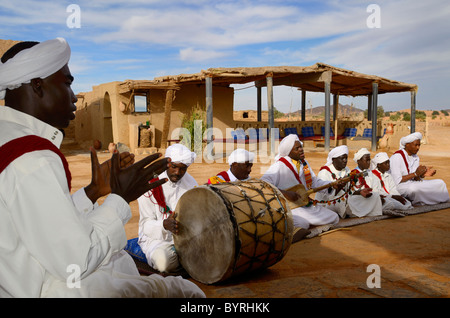 Tauben du Sable Gnawa Musikgruppe in weißen Turbanen und Djellabas spielen Trommel Hand Clap laute Gimbri in Khemliya Dorf Marokko Nordafrika Stockfoto