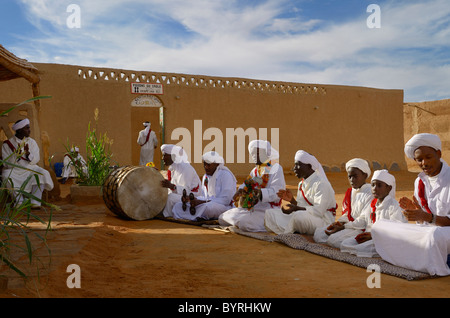 Gruppe der Gnawa-Musiker in weißen Turbanen und Djellabahs sitzen und spielen Musik in Khemliya Dorf Marokko Nordafrika Stockfoto