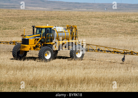 Ein RoGator gilt Herbizid für ein Getreidefeld in Trockengebieten im Frühjahr vor der Pflanzung eine neue Getreideernte / Alberta, Kanada. Stockfoto