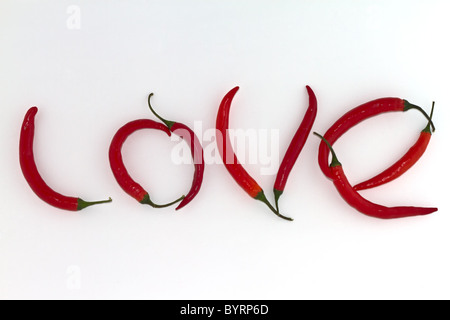 Rot-heiße Paprika angeordnet als das Wort Liebe auf weißem Hintergrund Stockfoto