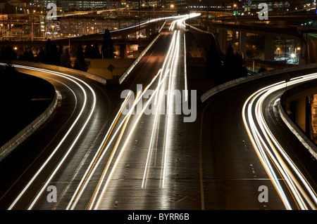 Schaut auf I90 in Seattle, Washington in der Nacht. Langzeitbelichtung fängt die Scheinwerfer und Rücklichter von Fahrzeugen vorbei. Stockfoto