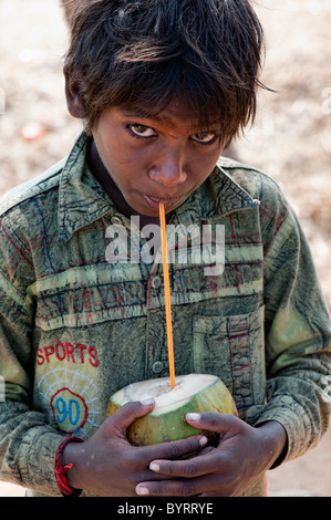 Glücklich Arm niedriger Kaste indischen Straße junge Kokoswasser trinken. Andhra Pradesh, Indien Stockfoto