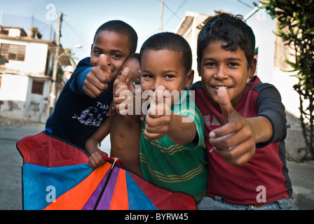 Jungs spielen mit Daumen eine Kite mit bis zu der Kamera, Santiago De Cuba, Kuba, Karibik. Stockfoto