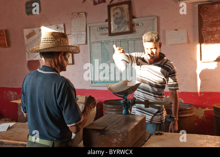 Cowboy mit einem Strohhut kaufen Reis in einen kleinen Laden mit einem Bild von Raul Castro, Kuba, Trinidad, Sancti Spiritus Stockfoto