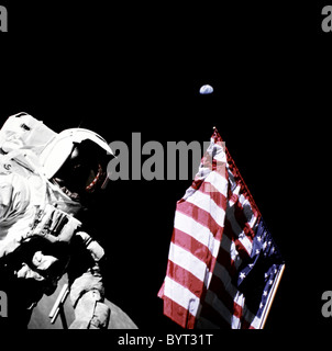 Apollo 17 Geologe und Astronaut Harrison Schmitt neben der US-Flagge mit der Erde hinter. Stockfoto