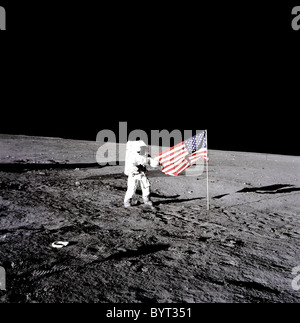 Apollo 12 Astronauten Charles "Pete" Conrad steht neben der USA-Flagge auf dem Mond. Stockfoto