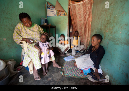 Eine Familie sitzt in ihrem ein-Zimmer-Haus im innerstädtischen Kampala, Uganda, Ostafrika. Stockfoto