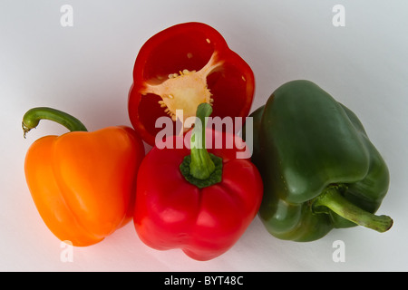 Rot, grün und Orange Pfeffer Früchte auf weiß. Eine Frucht in Scheiben geschnitten Stockfoto