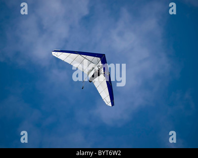 Nicht erkennbare Mann in einem Hängegleiter gegen einen wunderschönen blauen Himmel fliegen Stockfoto
