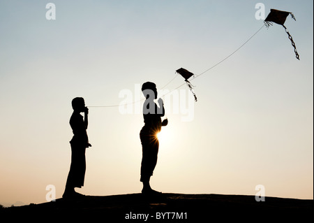 Indischen Jungen Spaß handgeschöpftes Papier Drachen in der indischen Landschaft. Silhouette Stockfoto