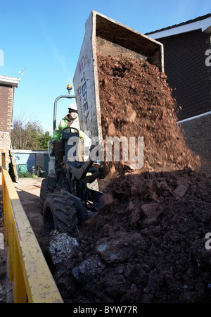 Muldenkipper Entleerung seine Schaufel voll Erde in ein überspringen Stockfoto