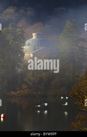 Belle Isle Rundhaus mit Schwäne fliegen vorbei an nebligen Tag im See widerspiegelt Stockfoto