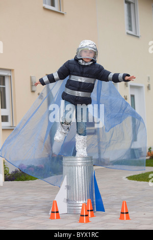 Junge gekleidet als Raumfahrer, versucht zu fliegen Stockfoto