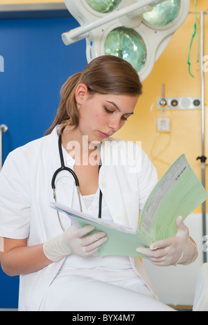 Krankenschwester untersucht Krankenakte Stockfoto