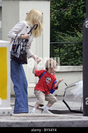 Gibt Claudia Schiffer nimmt ihren Sohn Caspar zur Schule.  Das Supermodel Sohn war für das nasse Wetter vorbereitet, wie er ist Stockfoto