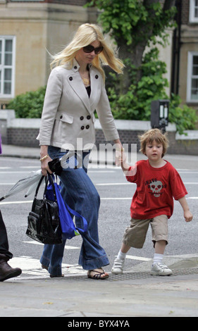 Gibt Claudia Schiffer nimmt ihren Sohn Caspar zur Schule.  Das Supermodel Sohn war für das nasse Wetter vorbereitet, wie er ist Stockfoto